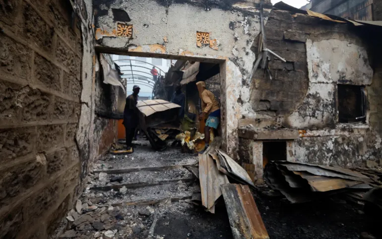 People salvage steel from buildings torched during demonstrations to mark the first anniversary of the deadly 2024 antigovernment protests that drew widespread condemnation over the use of force by security agencies, in downtown Nairobi, Kenya, on June 26, 2025 [Thomas Mukoya/Reuters]