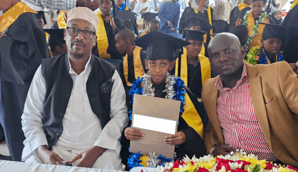 Dr. Mohamed Abdinoor Dahir, a young graduate, and another man at a graduation ceremony.